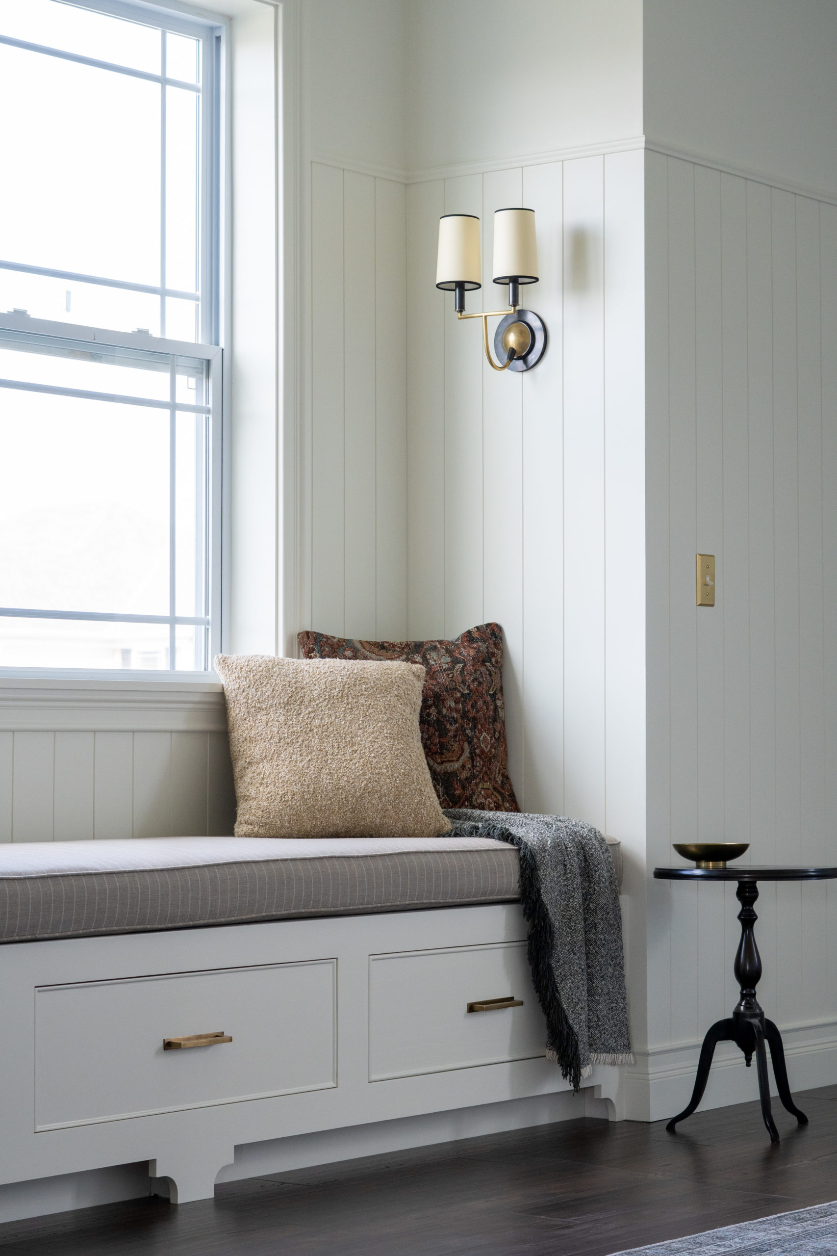 Window seat with a ticking stripe, taupe colored cushion. 